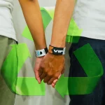 couple holding hands at event while wearing ecobands wristbands with recycle graphic logo in the background