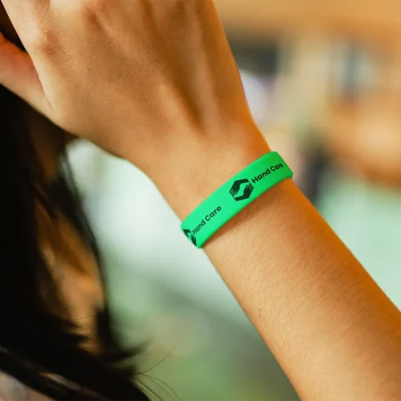 green bright custom silicon wristband with black lettering for charity on wrist of women at charity event