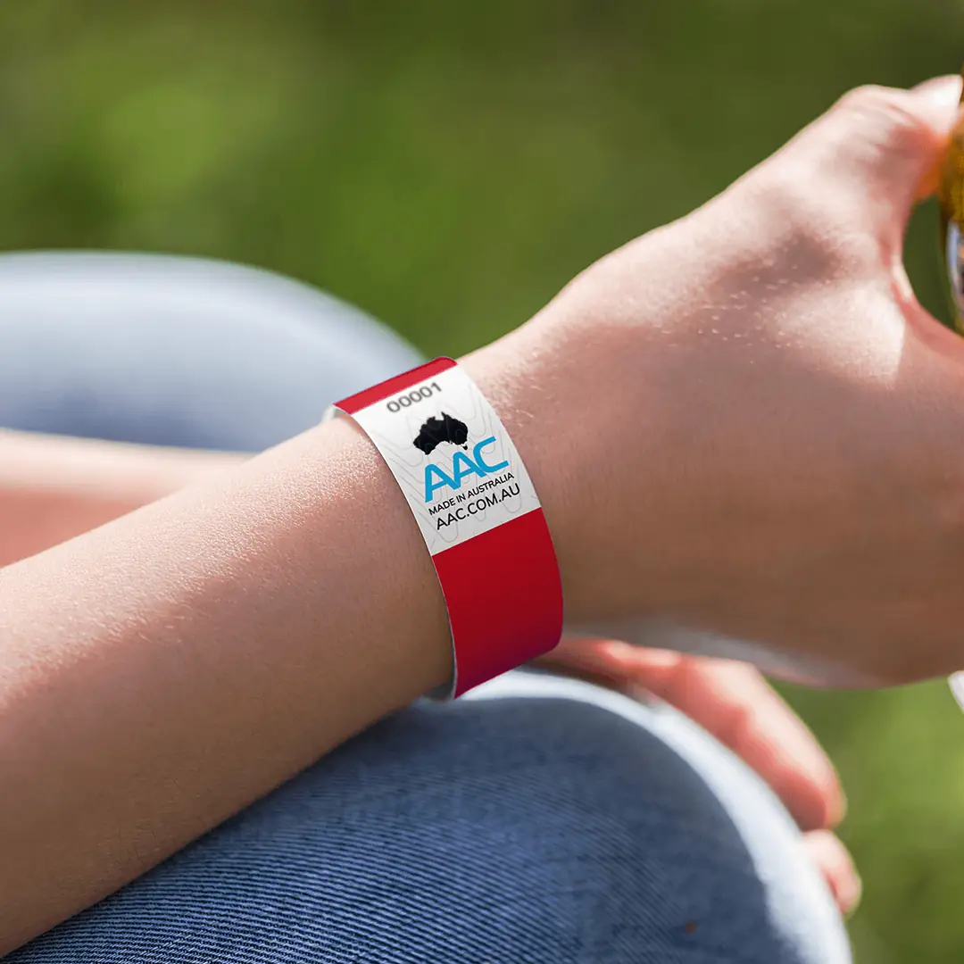 plain red ecobands wristband on the wrist of person at festival