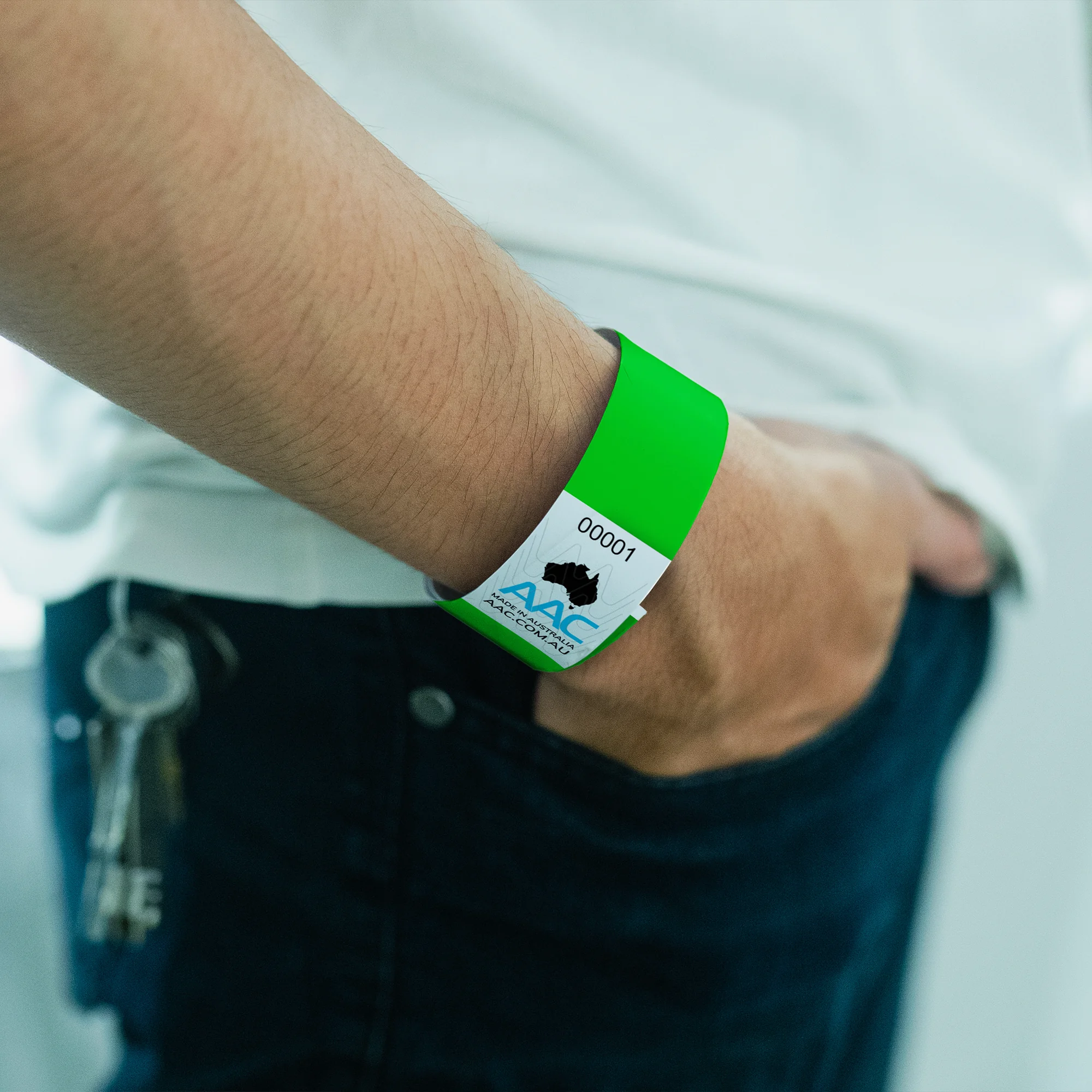 plain ecobands wristbands on the wrist with hand in pocket in neon green colour