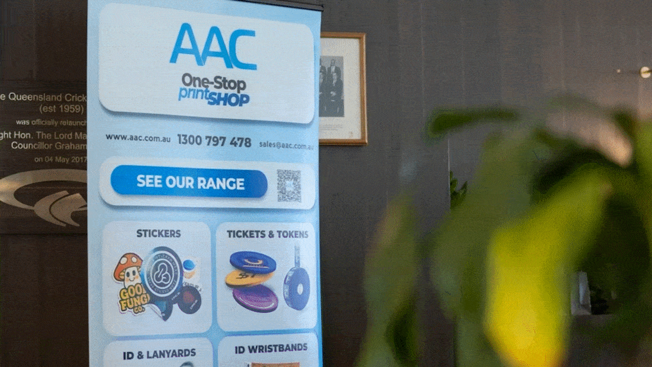 people walk past a blue aac, one stop shop pull up banner at conference