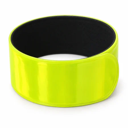 Neon yellow reflective PVC slapband curled into a wrist loop with black inner backing