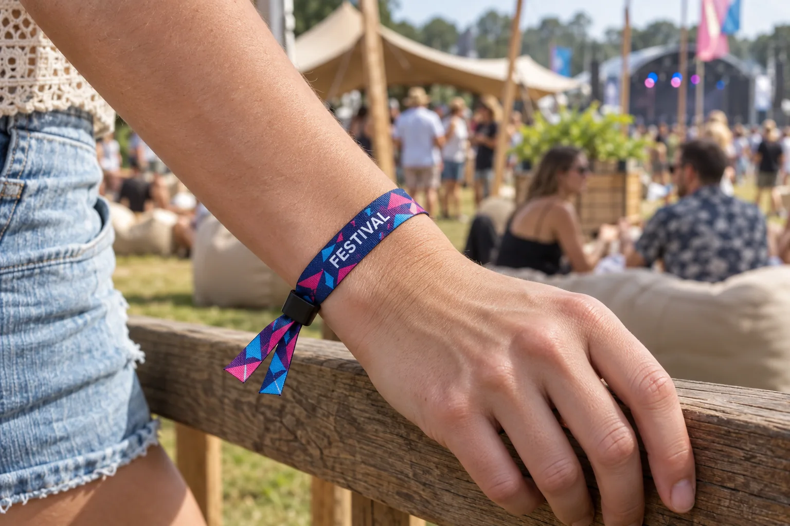Guest wearing a colourful printed fabric wristband with a black slide lock at a festival.