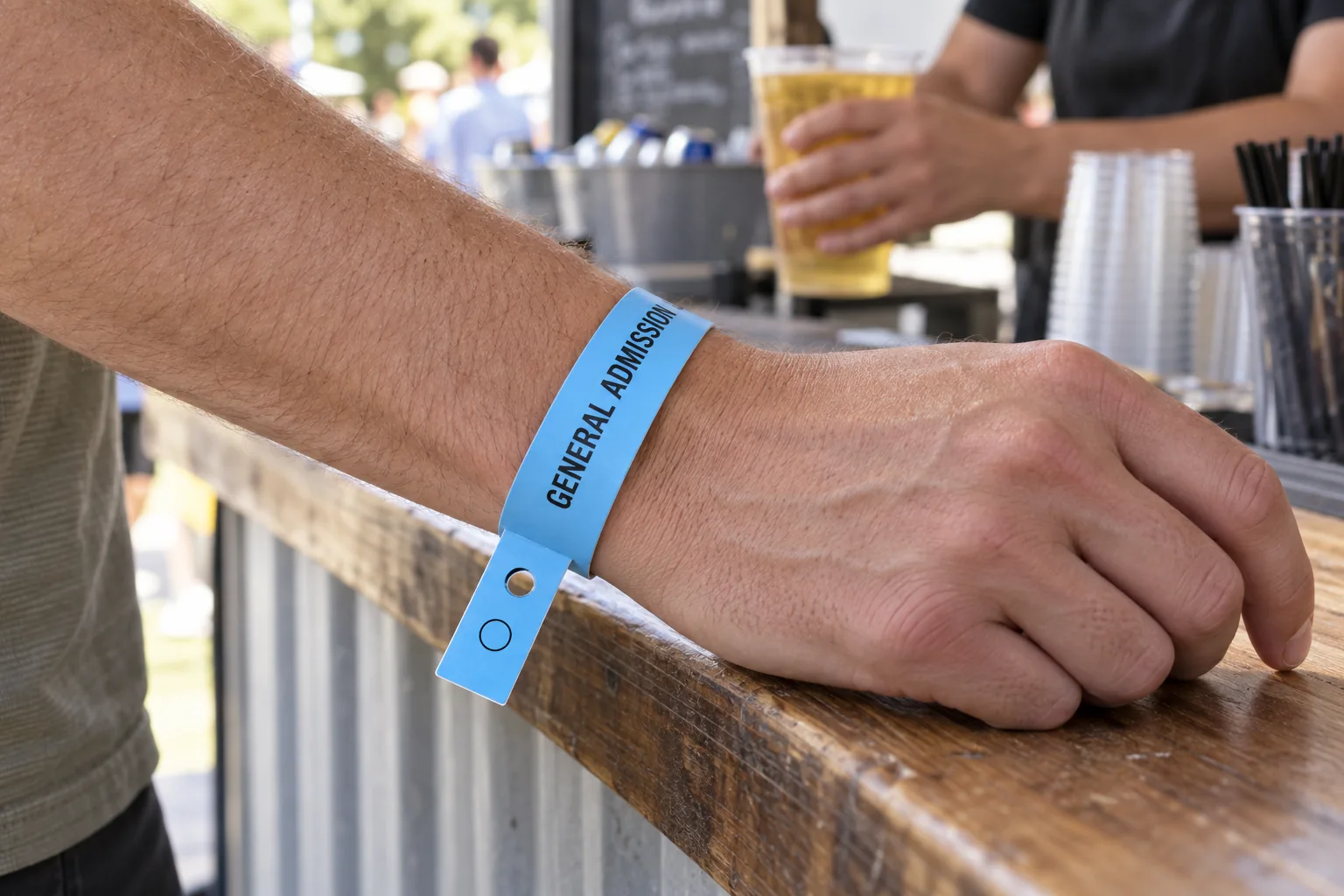 Guest wearing a blue Voucherband with a short hole-punched redemption tail at an event counter.